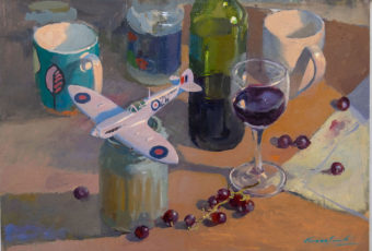 Oil painting of a toy aeroplane, a glass of red wine, a third full bottle of red wine, some red grapes and a few mugs used as props in the studio of Tasmanian artist Rick Crossland